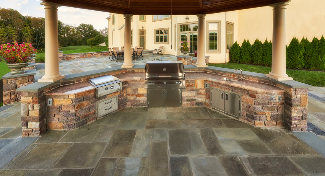 Outdoor kitchen and living area photo by EDW Builders